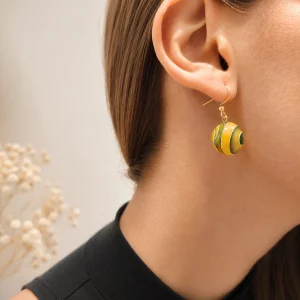photo d'une personne portant des boucles d'oreilles en résine jeune et verte