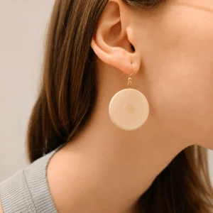Image d'une personne portant des boucle d'oreille en houx
