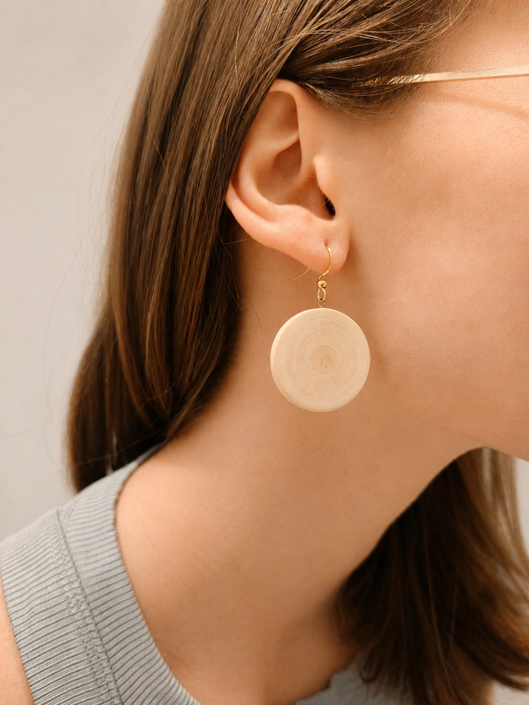 Image d'une personne portant des boucle d'oreille en houx